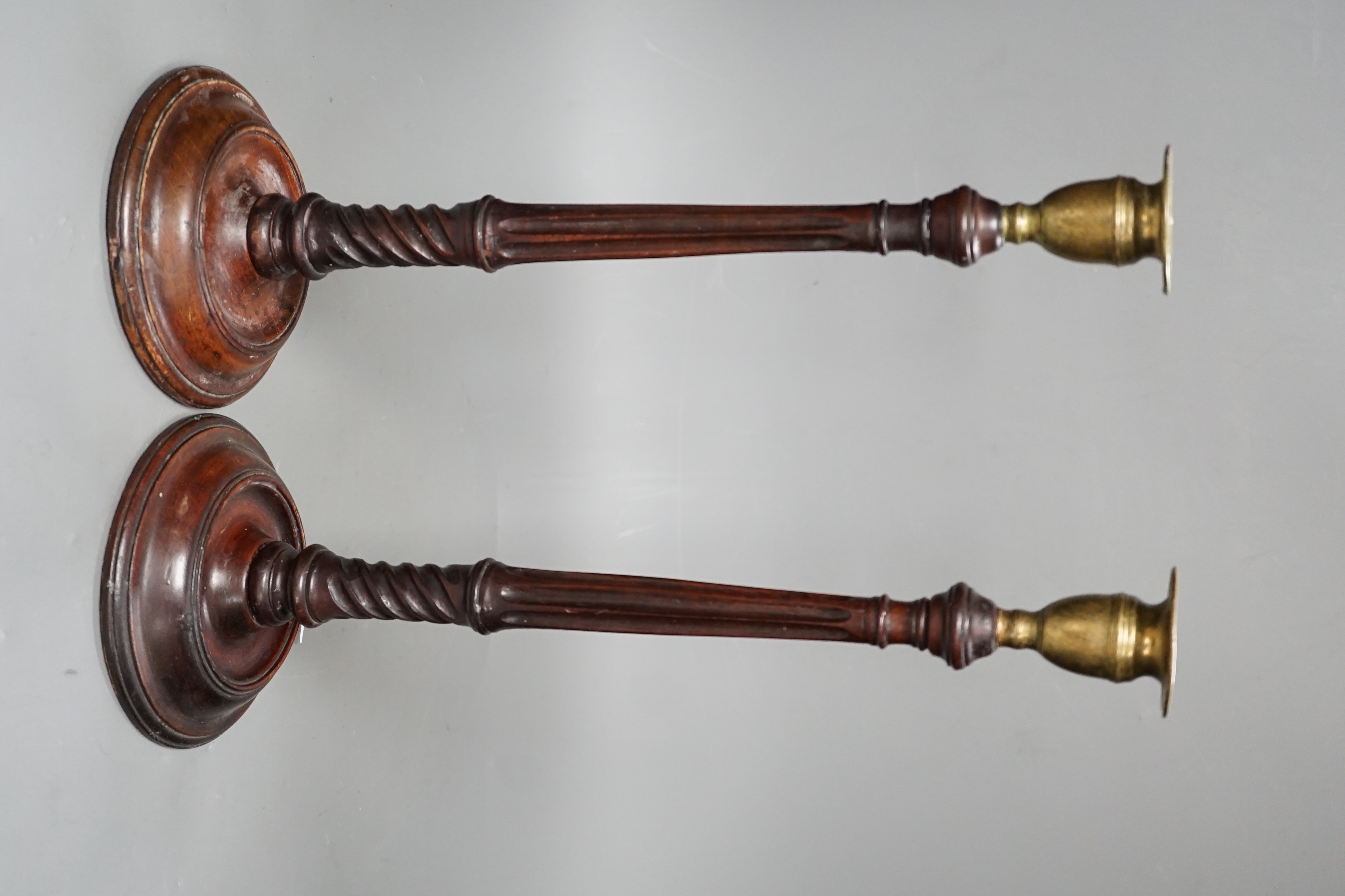 A pair of George III style carved mahogany candlesticks, with brass sconces, 38cms high